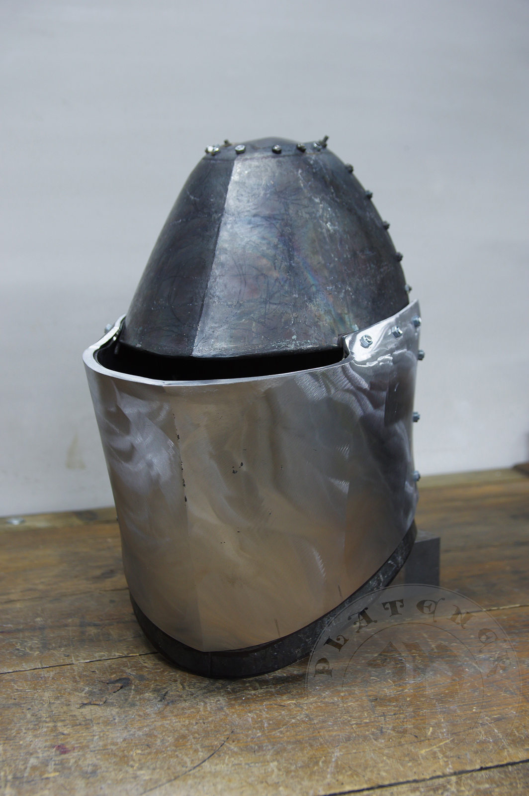 My interpretation of a tournament helm based on the Henry V helm - part of his funeral achievement from Westminster Abbey. It represents an early style of jousting helm dated for 1380-1420. It is composed of five primary plates: rear plate, brown plate, crown plate, face plate and monstrous thick reinforcing plate in front.