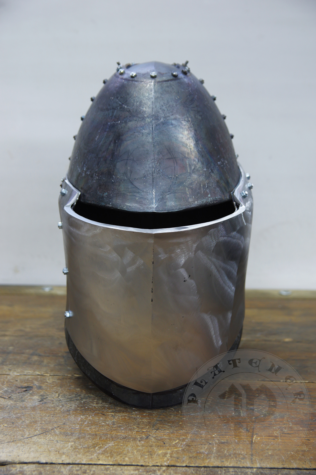 My interpretation of a tournament helm based on the Henry V helm - part of his funeral achievement from Westminster Abbey. It represents an early style of jousting helm dated for 1380-1420. It is composed of five primary plates: rear plate, brown plate, crown plate, face plate and monstrous thick reinforcing plate in front.