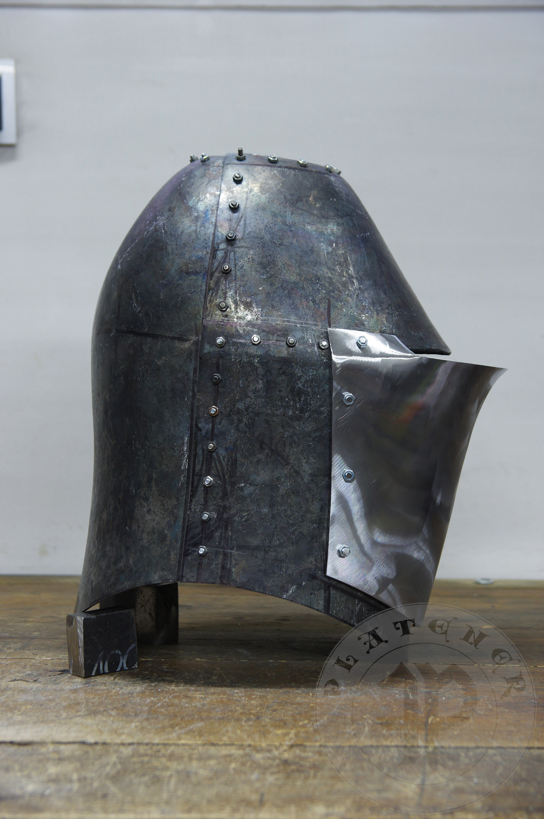 My interpretation of a tournament helm based on the Henry V helm - part of his funeral achievement from Westminster Abbey. It represents an early style of jousting helm dated for 1380-1420. It is composed of five primary plates: rear plate, brown plate, crown plate, face plate and monstrous thick reinforcing plate in front.