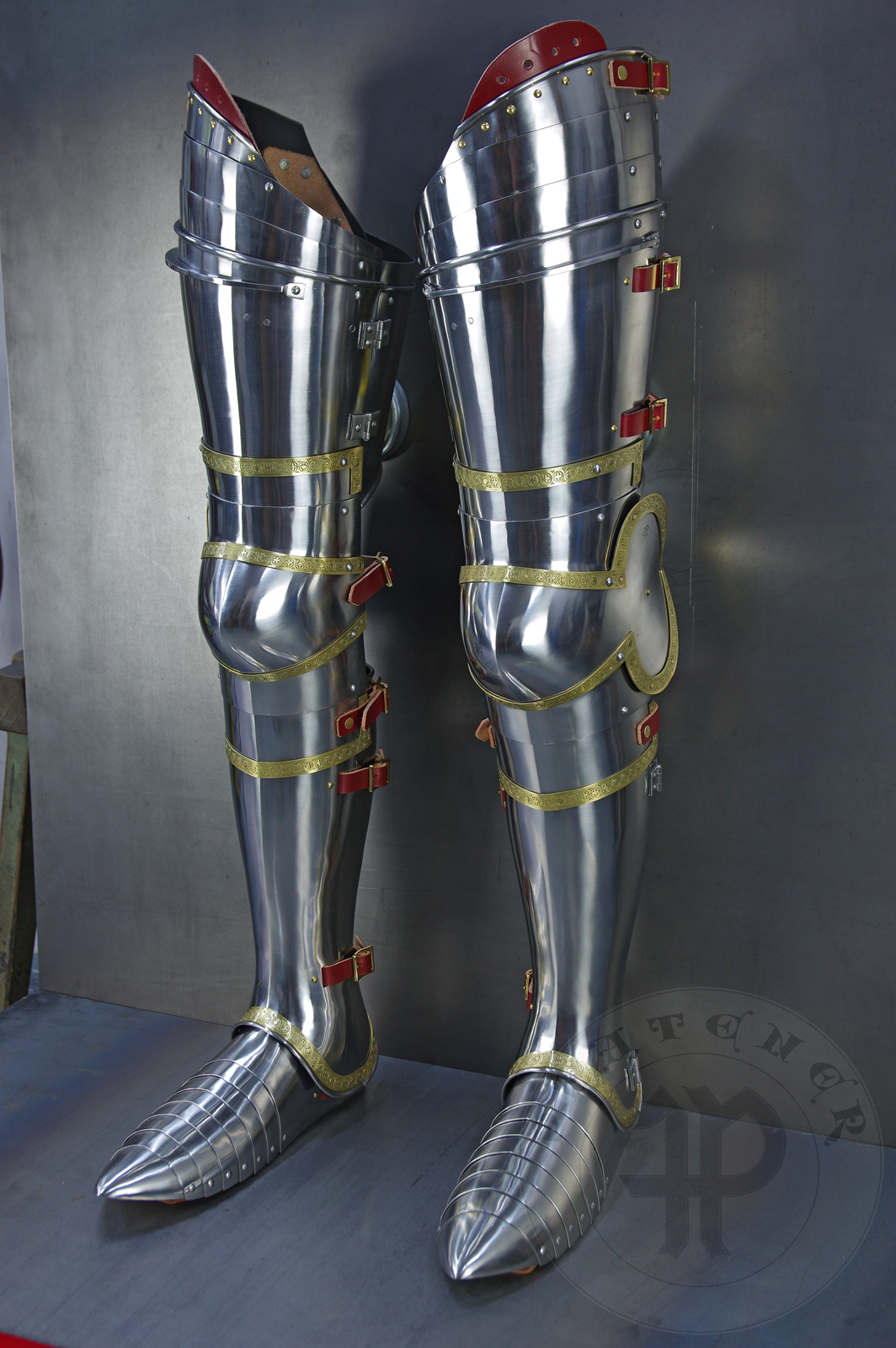 Complete leg harness mainly inspired by depicts from Altar of St George of the Valencian school, circa 1410. Cuisses are quite unusual with such detail like lames on upper part of thigh plates and stop ribs. They are also closed at the back like in English style armour. All made of medium carbon steel and heat hardened and tempered up to 42 HRC./Pene osony ng gwnie inspirowane przedstawieniami z otarza w. Jerzego z warsztatu z Walencji, okoo 1410 rok. Nabiodrki s do nietypowe z takimi detalami jak dodatkowe folgi oraz kute wzmocnienie ochronne. S one take w peni zamknite podobnie jak w angielskim stylu. Wykonane w caoci ze stali redniowglowej oraz hartowane i odpuszczane do twardoci 42 HRC.