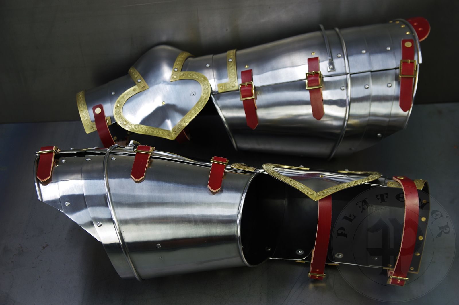 Complete leg harness mainly inspired by depicts from Altar of St George of the Valencian school, circa 1410. Cuisses are quite unusual with such detail like lames on upper part of thigh plates and stop ribs. They are also closed at the back like in English style armour. All made of medium carbon steel and heat hardened and tempered up to 42 HRC./Pene osony ng gwnie inspirowane przedstawieniami z otarza w. Jerzego z warsztatu z Walencji, okoo 1410 rok. Nabiodrki s do nietypowe z takimi detalami jak dodatkowe folgi oraz kute wzmocnienie ochronne. S one take w peni zamknite podobnie jak w angielskim stylu. Wykonane w caoci ze stali redniowglowej oraz hartowane i odpuszczane do twardoci 42 HRC.