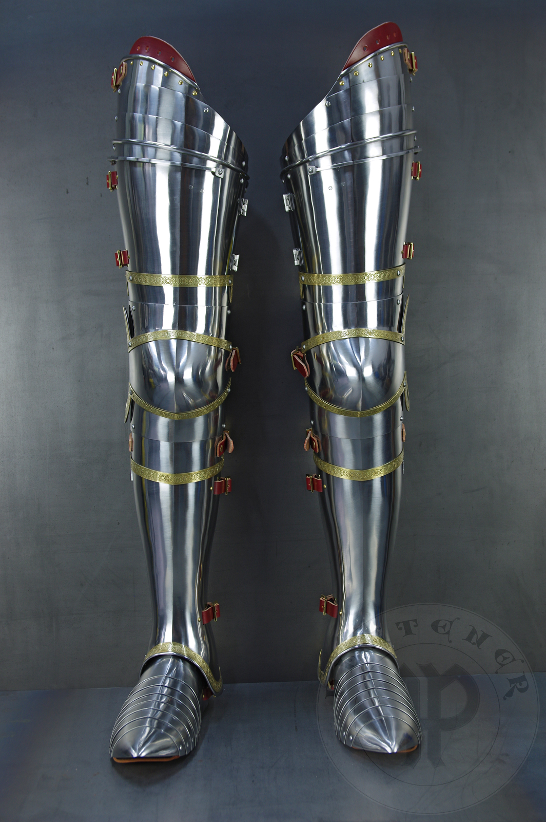 Complete leg harness mainly inspired by depicts from Altar of St George of the Valencian school, circa 1410. Cuisses are quite unusual with such detail like lames on upper part of thigh plates and stop ribs. They are also closed at the back like in English style armour. All made of medium carbon steel and heat hardened and tempered up to 42 HRC./Pene osony ng gwnie inspirowane przedstawieniami z otarza w. Jerzego z warsztatu z Walencji, okoo 1410 rok. Nabiodrki s do nietypowe z takimi detalami jak dodatkowe folgi oraz kute wzmocnienie ochronne. S one take w peni zamknite podobnie jak w angielskim stylu. Wykonane w caoci ze stali redniowglowej oraz hartowane i odpuszczane do twardoci 42 HRC.