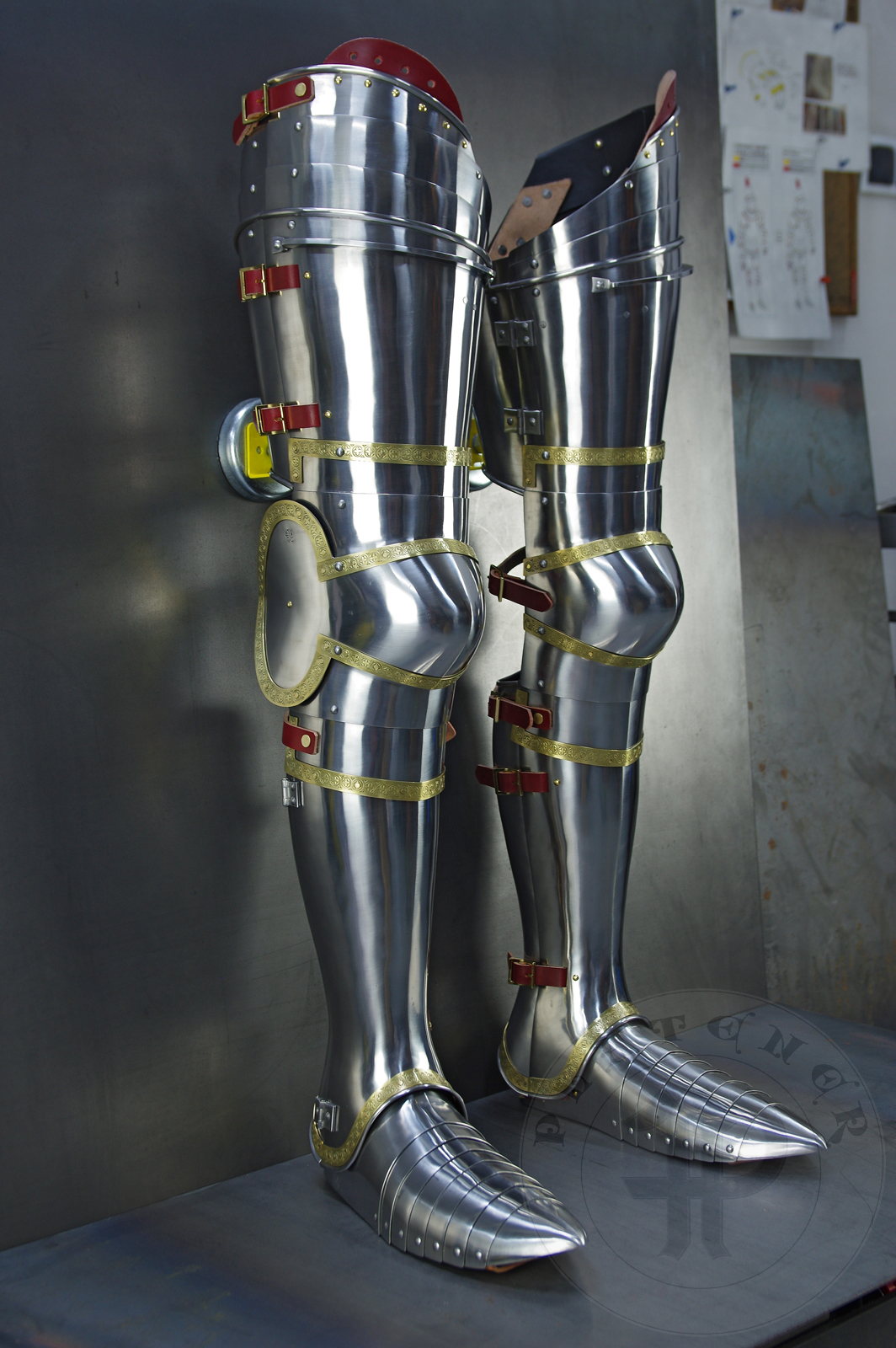 Complete leg harness mainly inspired by depicts from Altar of St George of the Valencian school, circa 1410. Cuisses are quite unusual with such detail like lames on upper part of thigh plates and stop ribs. They are also closed at the back like in English style armour. All made of medium carbon steel and heat hardened and tempered up to 42 HRC./Pene osony ng gwnie inspirowane przedstawieniami z otarza w. Jerzego z warsztatu z Walencji, okoo 1410 rok. Nabiodrki s do nietypowe z takimi detalami jak dodatkowe folgi oraz kute wzmocnienie ochronne. S one take w peni zamknite podobnie jak w angielskim stylu. Wykonane w caoci ze stali redniowglowej oraz hartowane i odpuszczane do twardoci 42 HRC.