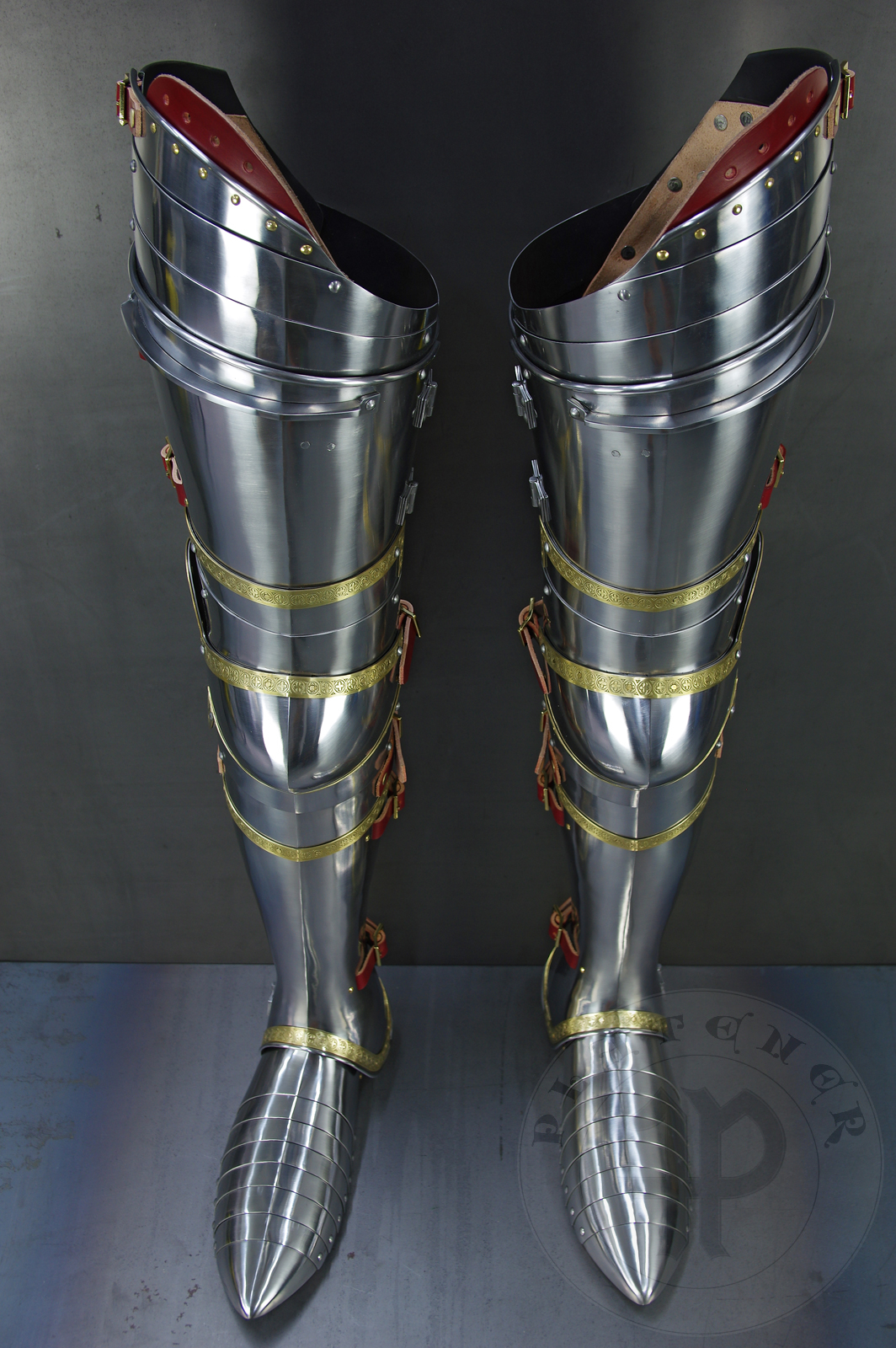 Complete leg harness mainly inspired by depicts from Altar of St George of the Valencian school, circa 1410. Cuisses are quite unusual with such detail like lames on upper part of thigh plates and stop ribs. They are also closed at the back like in English style armour. All made of medium carbon steel and heat hardened and tempered up to 42 HRC./Pene osony ng gwnie inspirowane przedstawieniami z otarza w. Jerzego z warsztatu z Walencji, okoo 1410 rok. Nabiodrki s do nietypowe z takimi detalami jak dodatkowe folgi oraz kute wzmocnienie ochronne. S one take w peni zamknite podobnie jak w angielskim stylu. Wykonane w caoci ze stali redniowglowej oraz hartowane i odpuszczane do twardoci 42 HRC.