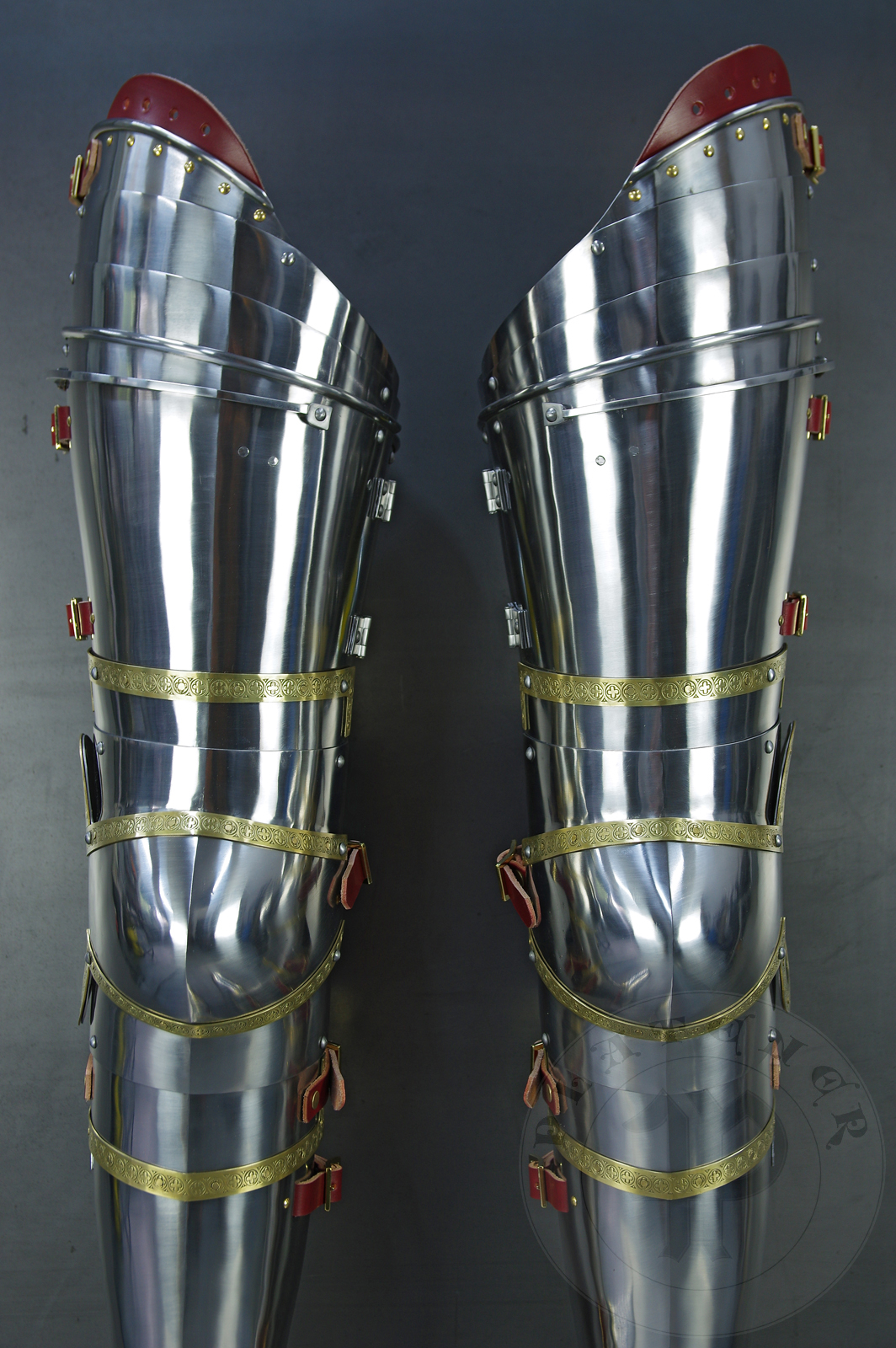 Complete leg harness mainly inspired by depicts from Altar of St George of the Valencian school, circa 1410. Cuisses are quite unusual with such detail like lames on upper part of thigh plates and stop ribs. They are also closed at the back like in English style armour. All made of medium carbon steel and heat hardened and tempered up to 42 HRC./Pene osony ng gwnie inspirowane przedstawieniami z otarza w. Jerzego z warsztatu z Walencji, okoo 1410 rok. Nabiodrki s do nietypowe z takimi detalami jak dodatkowe folgi oraz kute wzmocnienie ochronne. S one take w peni zamknite podobnie jak w angielskim stylu. Wykonane w caoci ze stali redniowglowej oraz hartowane i odpuszczane do twardoci 42 HRC.