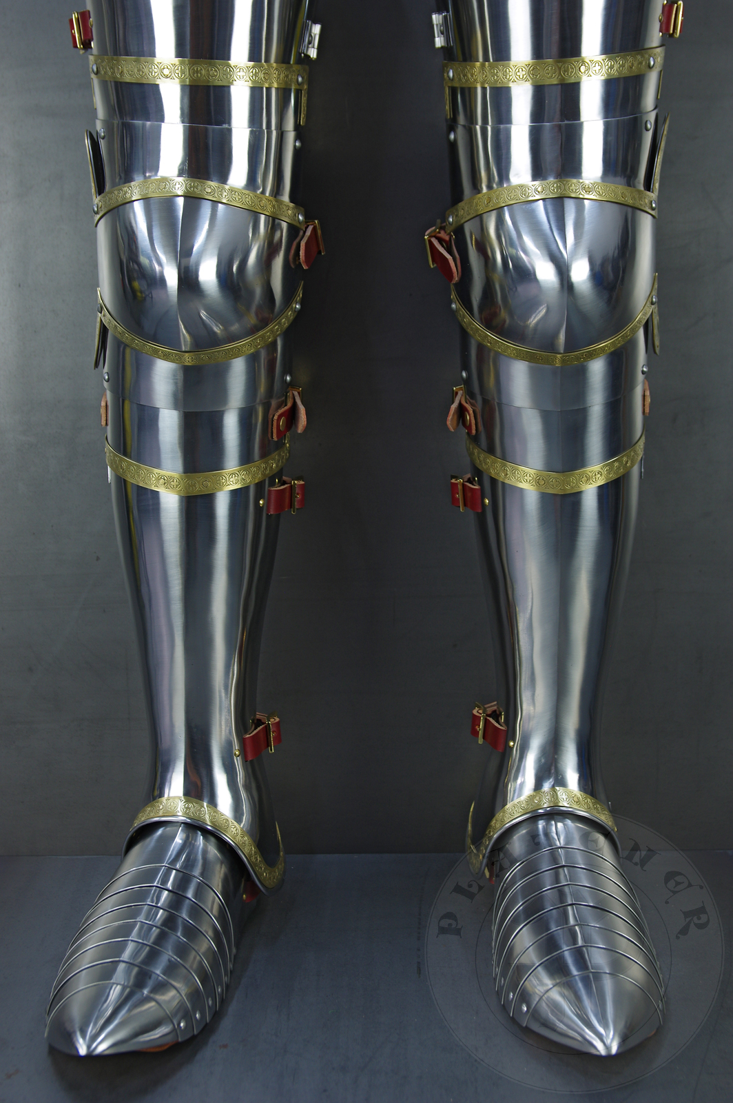 Complete leg harness mainly inspired by depicts from Altar of St George of the Valencian school, circa 1410. Cuisses are quite unusual with such detail like lames on upper part of thigh plates and stop ribs. They are also closed at the back like in English style armour. All made of medium carbon steel and heat hardened and tempered up to 42 HRC./Pene osony ng gwnie inspirowane przedstawieniami z otarza w. Jerzego z warsztatu z Walencji, okoo 1410 rok. Nabiodrki s do nietypowe z takimi detalami jak dodatkowe folgi oraz kute wzmocnienie ochronne. S one take w peni zamknite podobnie jak w angielskim stylu. Wykonane w caoci ze stali redniowglowej oraz hartowane i odpuszczane do twardoci 42 HRC.