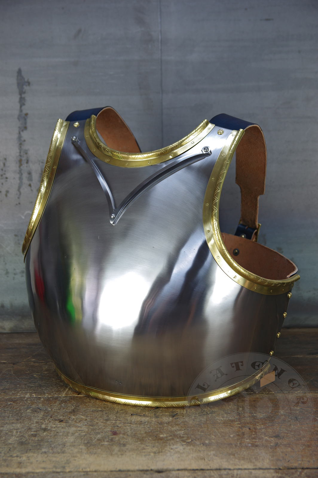 Here is a classic breastplate with V-neck stop rib (to deflect thrusts away from the neck) based on Churburg CH14. I enhanced its simple aesthetic by adding brass decorations around the edges with a geometrical, hand filed pattern. They were inspired by decorations from Churburg CH13 segmented breastplate and depictions in art from this period