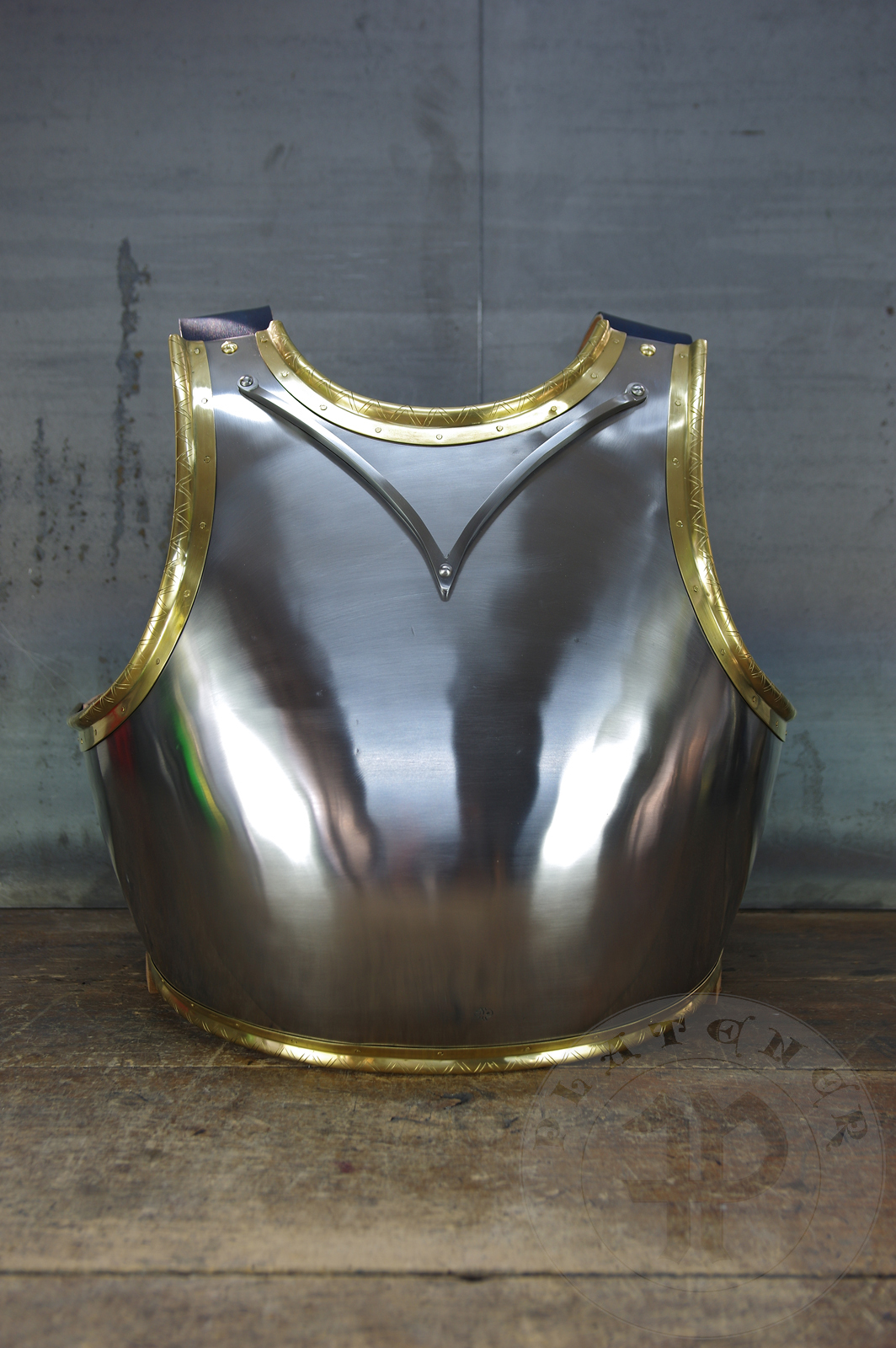 Here is a classic breastplate with V-neck stop rib (to deflect thrusts away from the neck) based on Churburg CH14. I enhanced its simple aesthetic by adding brass decorations around the edges with a geometrical, hand filed pattern. They were inspired by decorations from Churburg CH13 segmented breastplate and depictions in art from this period