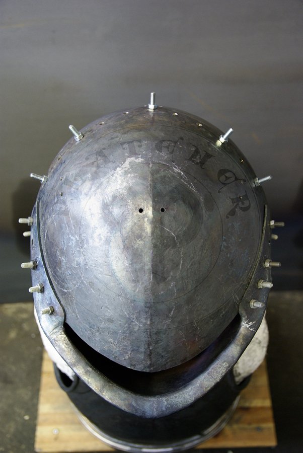 Stechhelm na pocztek XV wieku, wykonany z wysokiej jakoci stali niskowglowej. Przednia oraz grna pyta wykonane z stali o gruboci 3 mm, zawinicie ma 2,2 cm gruboci z przodu i 1,8 cm gruboci po bokach. Tylna pyta wykonana z 2,5 mm stali. Hem hartowany i odpuszczany do 30 HRC. Waga 8 kg./Stechhelm for begin of XV c., made of high quality mild steel. Front and top part is from 3 mm thick steel, roll is 2,2 cm thick on front and 1,8 cm at sides. Back part is from 2,5 mm steel. It is heat hardened and tempered up to 30 HRC. Wieght 8 kg.