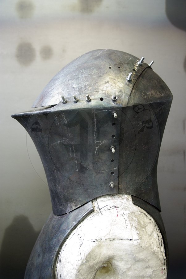 Stechhelm na pocztek XV wieku, wykonany z wysokiej jakoci stali niskowglowej. Przednia oraz grna pyta wykonane z stali o gruboci 3 mm, zawinicie ma 2,2 cm gruboci z przodu i 1,8 cm gruboci po bokach. Tylna pyta wykonana z 2,5 mm stali. Hem hartowany i odpuszczany do 30 HRC. Waga 8 kg./Stechhelm for begin of XV c., made of high quality mild steel. Front and top part is from 3 mm thick steel, roll is 2,2 cm thick on front and 1,8 cm at sides. Back part is from 2,5 mm steel. It is heat hardened and tempered up to 30 HRC. Wieght 8 kg.
