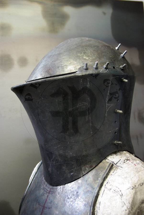 Stechhelm na pocztek XV wieku, wykonany z wysokiej jakoci stali niskowglowej. Przednia oraz grna pyta wykonane z stali o gruboci 3 mm, zawinicie ma 2,2 cm gruboci z przodu i 1,8 cm gruboci po bokach. Tylna pyta wykonana z 2,5 mm stali. Hem hartowany i odpuszczany do 30 HRC. Waga 8 kg./Stechhelm for begin of XV c., made of high quality mild steel. Front and top part is from 3 mm thick steel, roll is 2,2 cm thick on front and 1,8 cm at sides. Back part is from 2,5 mm steel. It is heat hardened and tempered up to 30 HRC. Wieght 8 kg.