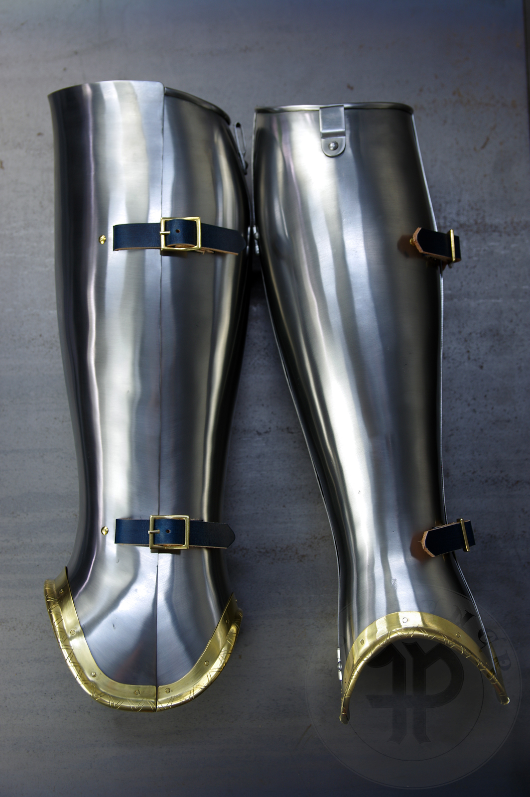 Late 14th/early 15th c. style full plate leg harness with brass decorations with a geometrical, hand filed pattern. Material: medium carbon and spring steel of various thickness: 1 mm; 1,2 mm and 1,5 mm; brass; vegetable tanned leather. Heat treatment: cuisses (thigh plates, lames, poleyns and demi-graves) heat hardened and tempered up to 42 HRC.