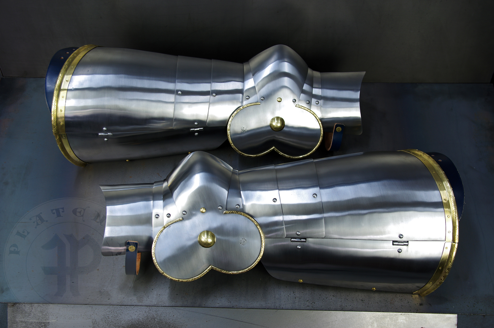 Late 14th/early 15th c. style full plate leg harness with brass decorations with a geometrical, hand filed pattern. Material: medium carbon and spring steel of various thickness: 1 mm; 1,2 mm and 1,5 mm; brass; vegetable tanned leather. Heat treatment: cuisses (thigh plates, lames, poleyns and demi-graves) heat hardened and tempered up to 42 HRC.