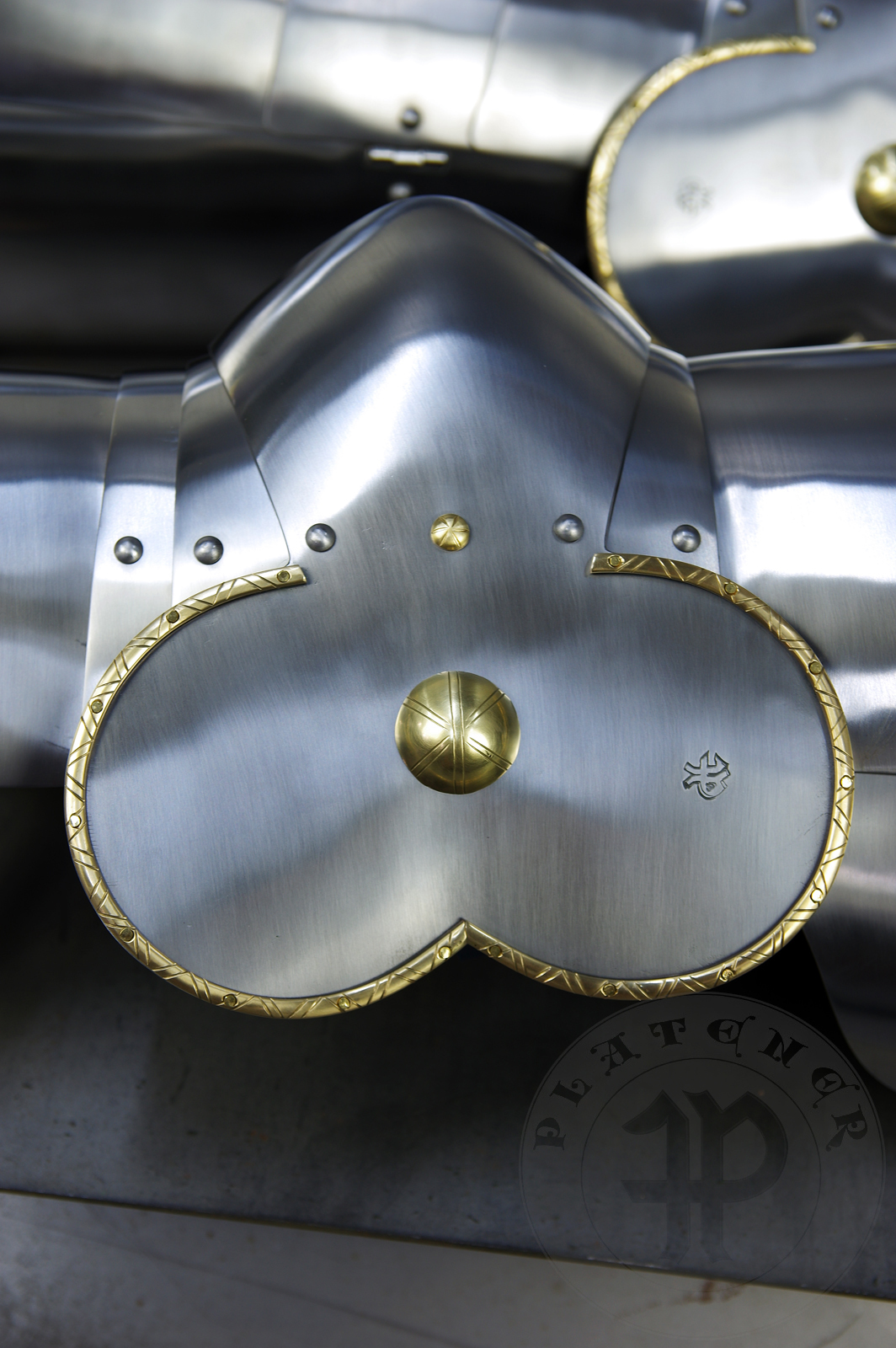 Late 14th/early 15th c. style full plate leg harness with brass decorations with a geometrical, hand filed pattern. Material: medium carbon and spring steel of various thickness: 1 mm; 1,2 mm and 1,5 mm; brass; vegetable tanned leather. Heat treatment: cuisses (thigh plates, lames, poleyns and demi-graves) heat hardened and tempered up to 42 HRC.