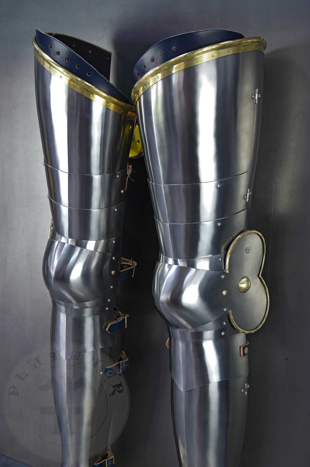 Late 14th/early 15th c. style full plate leg harness with brass decorations with a geometrical, hand filed pattern. Material: medium carbon and spring steel of various thickness: 1 mm; 1,2 mm and 1,5 mm; brass; vegetable tanned leather. Heat treatment: cuisses (thigh plates, lames, poleyns and demi-graves) heat hardened and tempered up to 42 HRC.