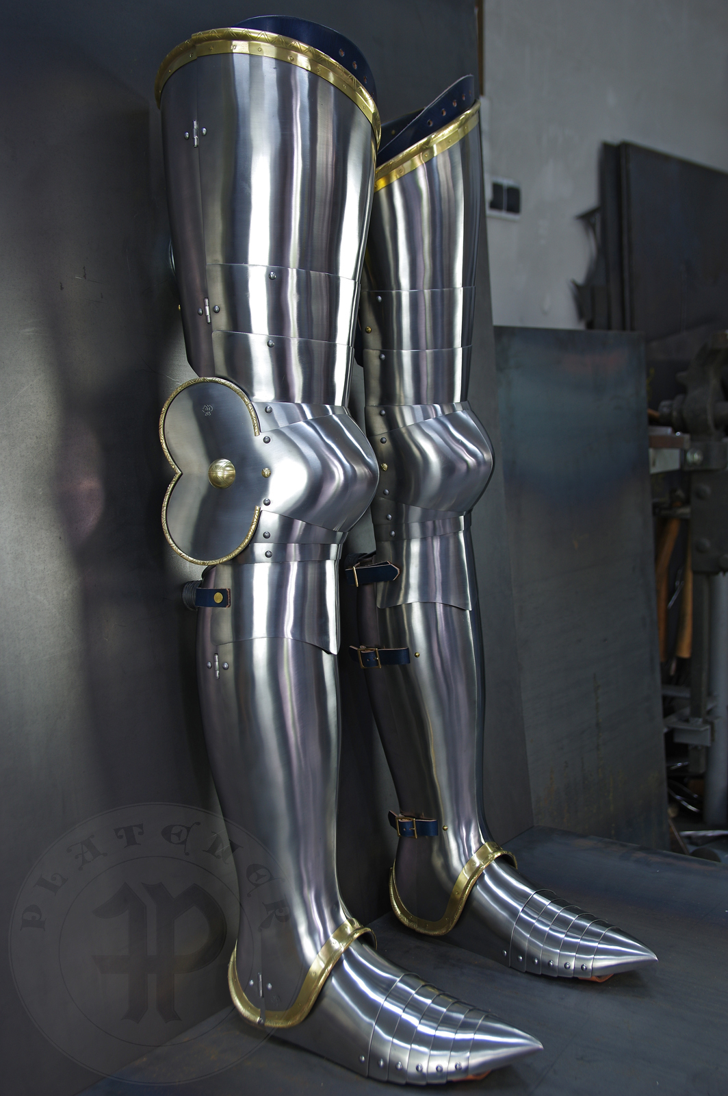 Late 14th/early 15th c. style full plate leg harness with brass decorations with a geometrical, hand filed pattern. Material: medium carbon and spring steel of various thickness: 1 mm; 1,2 mm and 1,5 mm; brass; vegetable tanned leather. Heat treatment: cuisses (thigh plates, lames, poleyns and demi-graves) heat hardened and tempered up to 42 HRC.