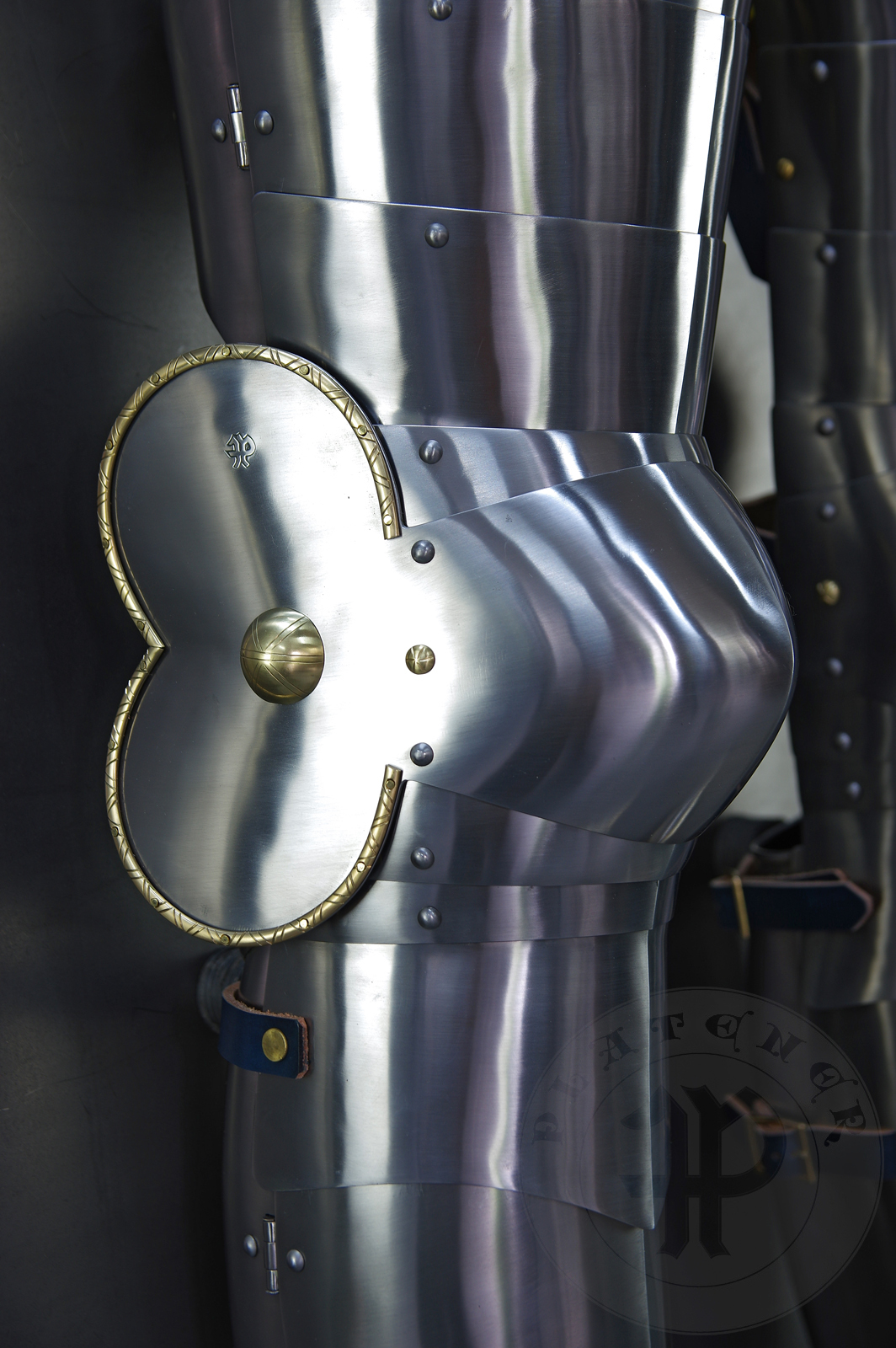 Late 14th/early 15th c. style full plate leg harness with brass decorations with a geometrical, hand filed pattern. Material: medium carbon and spring steel of various thickness: 1 mm; 1,2 mm and 1,5 mm; brass; vegetable tanned leather. Heat treatment: cuisses (thigh plates, lames, poleyns and demi-graves) heat hardened and tempered up to 42 HRC.