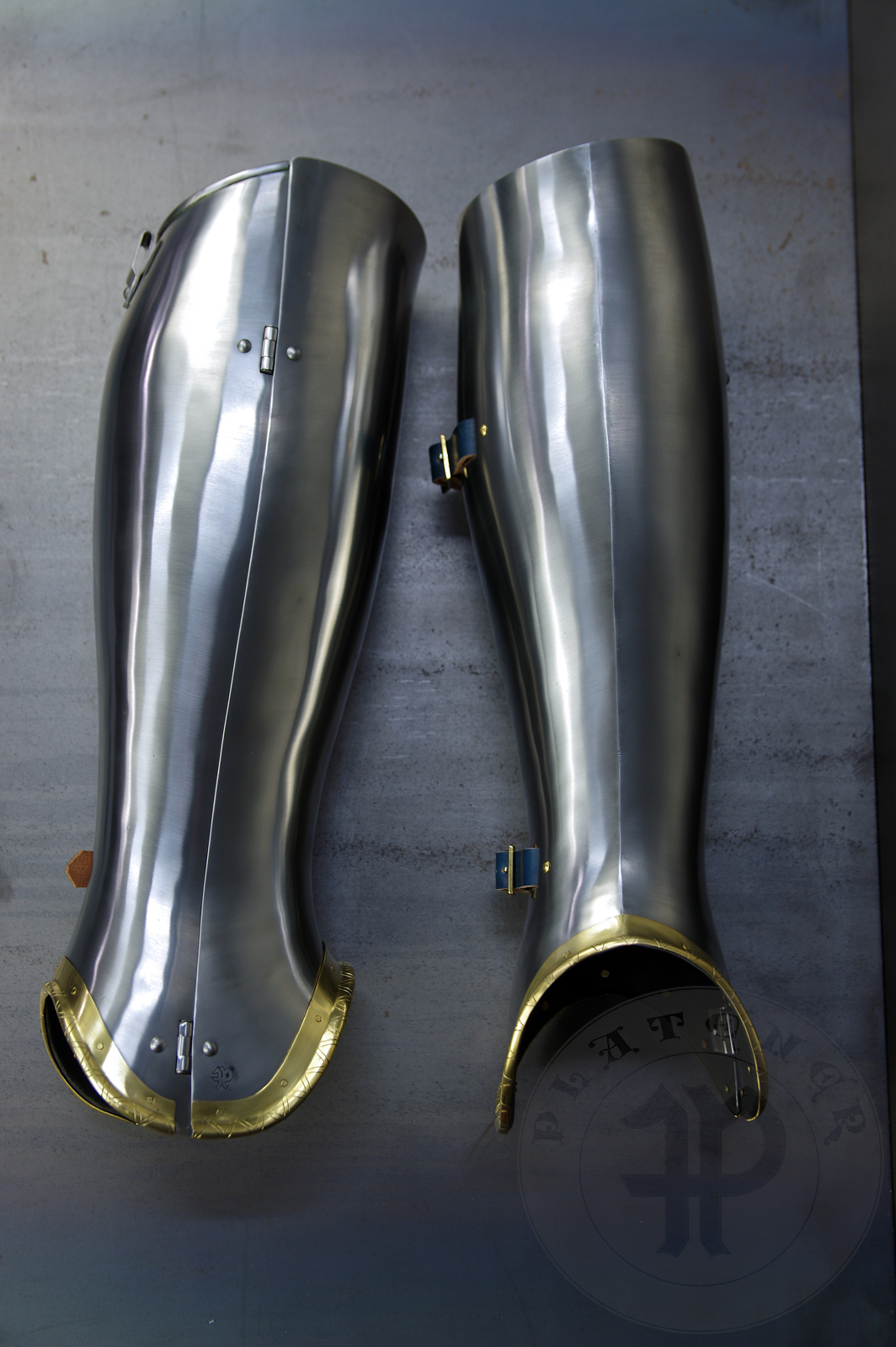 Late 14th/early 15th c. style full plate leg harness with brass decorations with a geometrical, hand filed pattern. Material: medium carbon and spring steel of various thickness: 1 mm; 1,2 mm and 1,5 mm; brass; vegetable tanned leather. Heat treatment: cuisses (thigh plates, lames, poleyns and demi-graves) heat hardened and tempered up to 42 HRC.