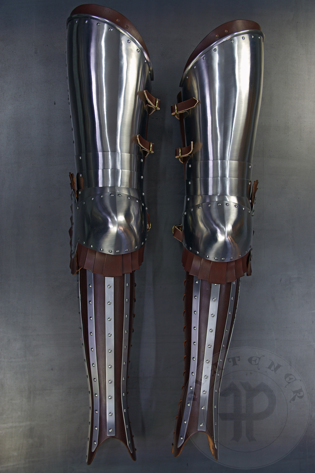 Transitional leg harness based on Guiron le Courtois Manuscript, 1370-1380. Made from medium carbon steel and spring steel 1,2 - 1,5 mm thick; leather 3 mm thick. Heat hardened and tempered up to 42 HRC. / Przejciowe osony ng wzorowane na manuskrypcie Guiron le Courtois, 1370-1380. Wykonane ze stali redniowglowej i sprynowej 1,2 mm - 1,5 mm; skra o gruboci 3 mm. Hartowane i odpuszczane do 42 HRC.  